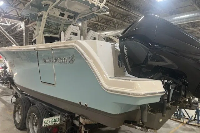 Slide: The Image of 2021 Sailfish 272 CC boat with dual engines on a trailer in a warehouse. - 15