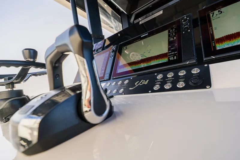 Slide: The Image of Control panel of 2023 Young 34 boat with navigation screens and throttle lever. - 32