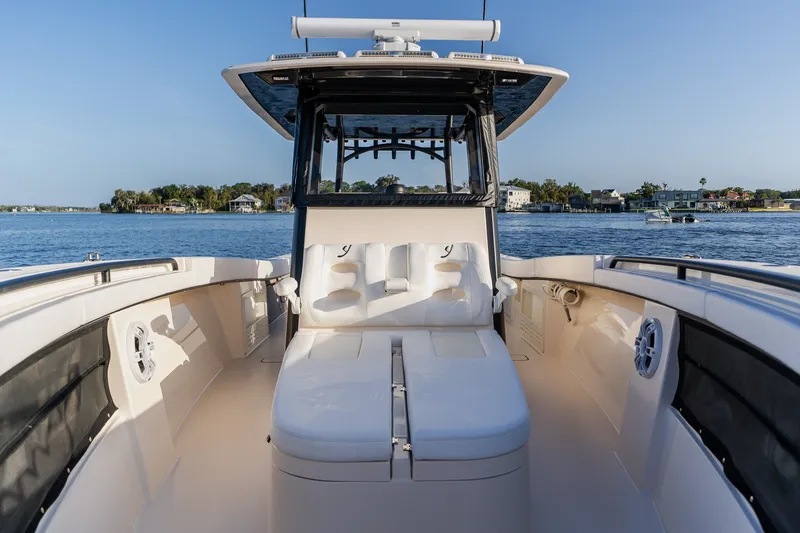 Slide: The Image of Luxury Young 34 boat interior with cushioned seating, cruising on a serene lake, 2023 model. - 22