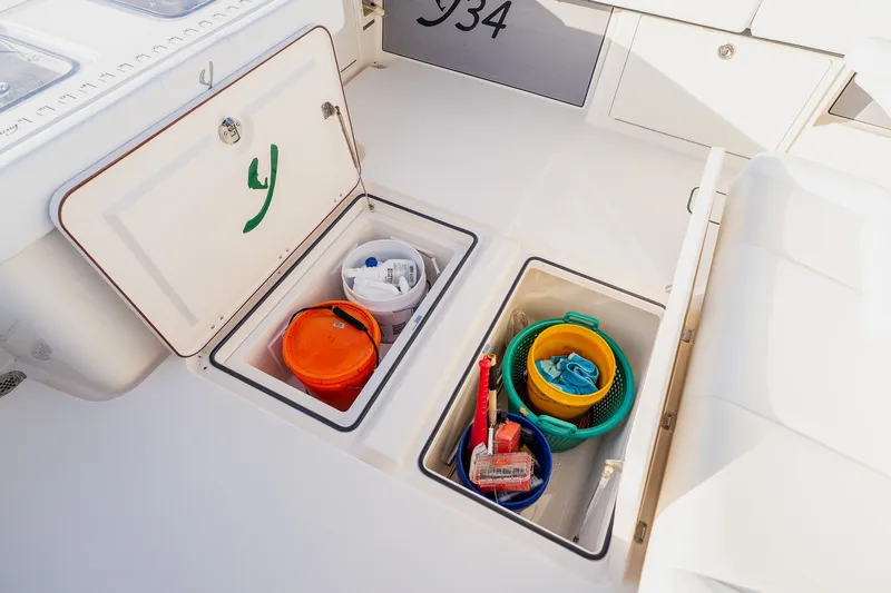 Slide: The Image of Storage compartments on a 2023 Young 34 boat, containing buckets and cleaning supplies. - 44