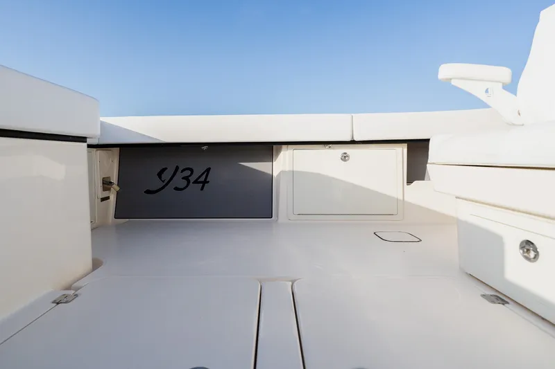 Slide: The Image of Interior view of 2023 Young 34 boat, featuring sleek white design and storage compartments. - 51
