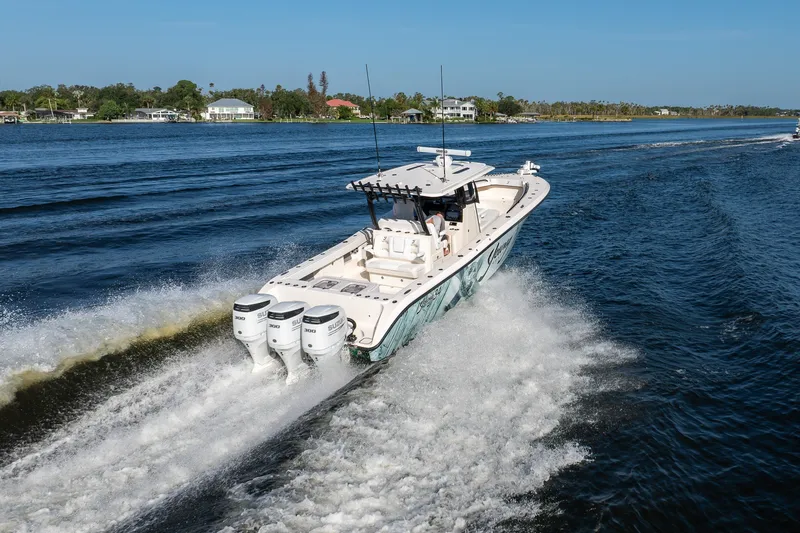 Slide: The Image of A 2023 Young 34 boat cruising swiftly on a scenic waterway. - 9