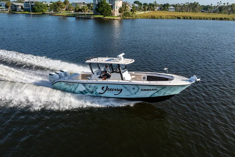 Slide: The Image of Young 34 boat cruising on a serene lake, 2023 model, with powerful engines. - 10