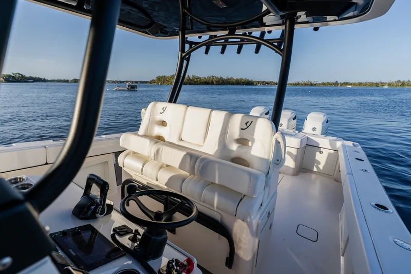 Slide: The Image of Modern 2023 Young 34 boat interior with steering wheel, white seating, and ocean view. - 28