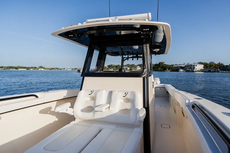 Slide: The Image of Luxury Young 34 boat interior, 2023 model, with plush seating on a serene waterway. - 26