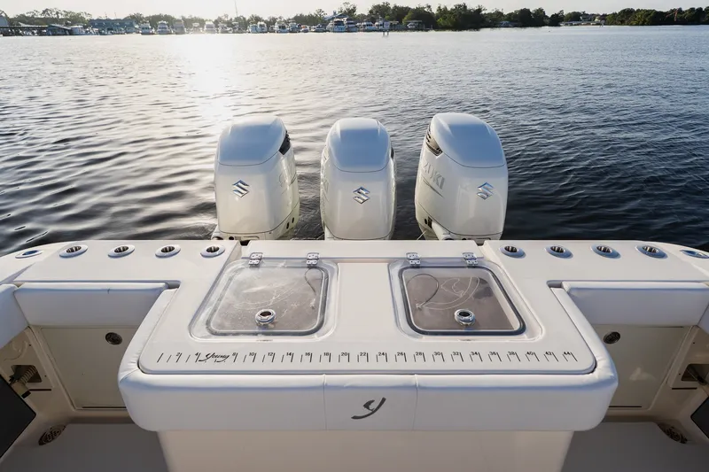 Slide: The Image of Triple outboard motors on a Young 34 boat, 2023 model, with a scenic water backdrop. - 45