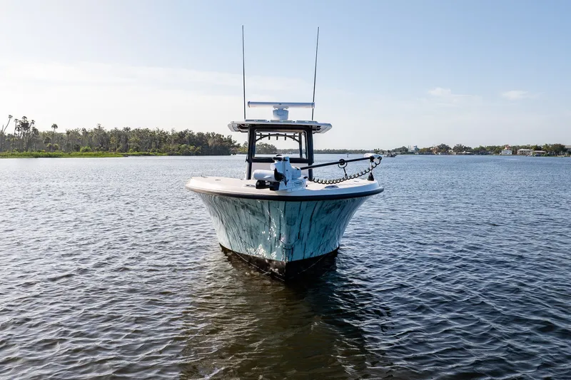 Slide: The Image of Young 34 boat on calm water, 2023 model, with scenic shoreline background. - 5