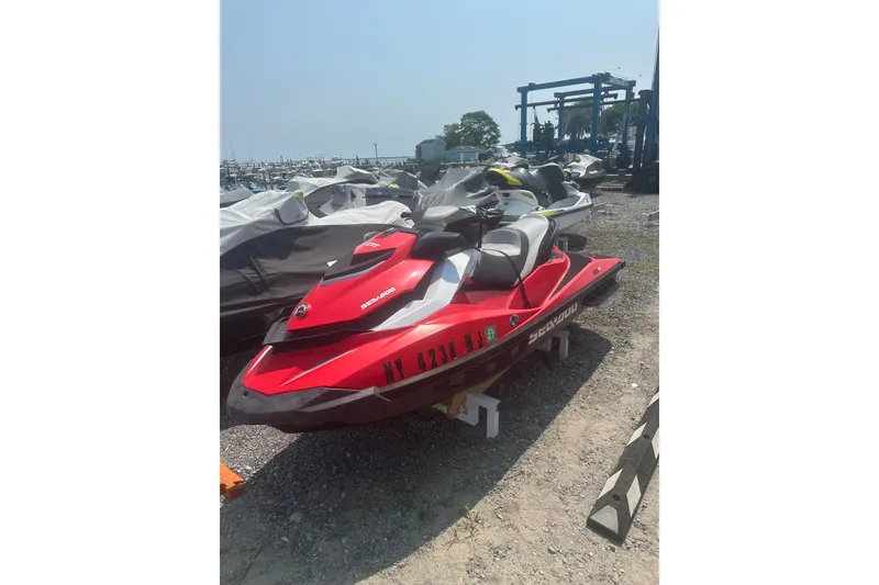 Slide: The Image of Red 2012 Sea-Doo GTI SE jet ski parked on gravel near marina. - 10