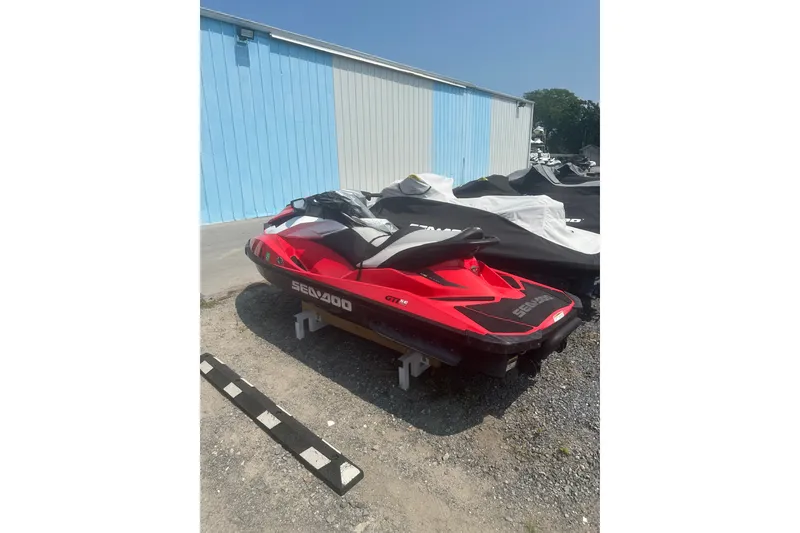 Slide: The Image of Red 2012 Sea-Doo GTI SE jet ski parked outdoors near a blue building. - 6