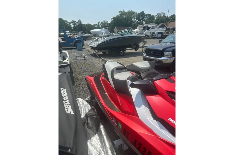 Slide: The Image of Red 2012 Sea-Doo GTI SE jet ski parked outdoors with other vehicles. - 2