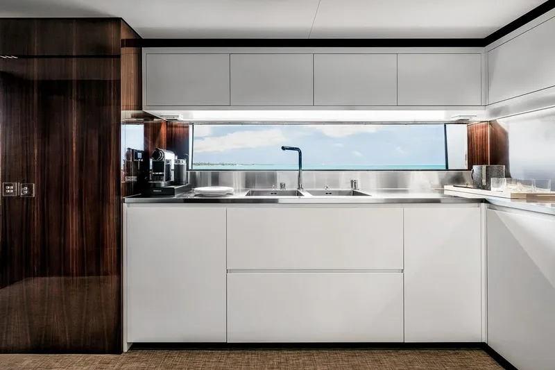 Slide: The Image of Modern kitchen interior on 2023 Riva 130' Bellissima yacht, featuring sleek cabinetry and ocean view. - 35