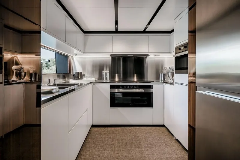 Slide: The Image of Modern kitchen interior on 2023 Riva 130' Bellissima yacht, featuring sleek white cabinetry. - 34