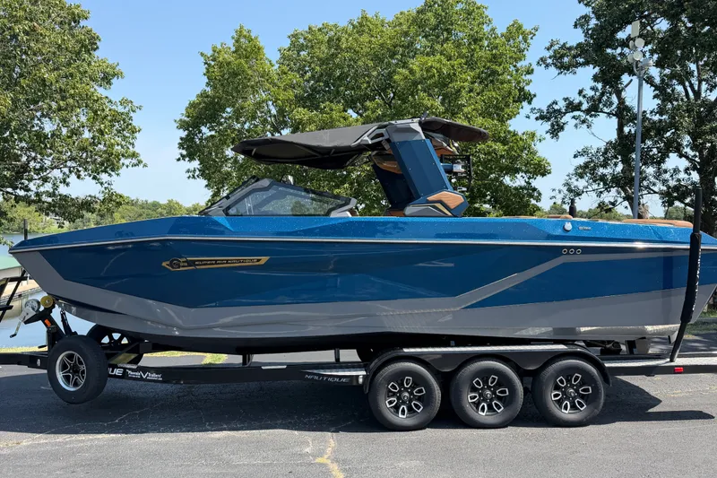 The Image of 2026 Nautique Super Air Nautique G25 boat on trailer, parked outdoors. - 1