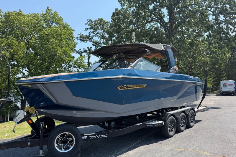 Slide: The Image of 2026 Nautique Super Air Nautique G25 boat on trailer, parked outdoors. - 5