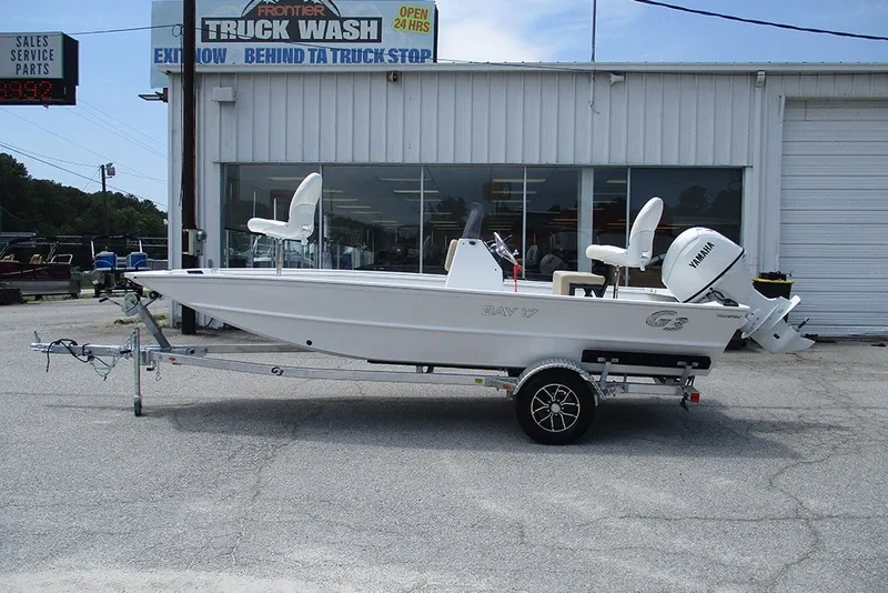The Image of 2026 G3 Bay 17 boat on trailer, parked outside a service shop. - 1