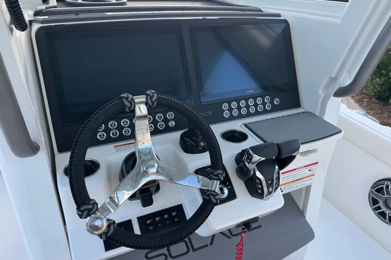 Slide: The Image of Steering console of 2027 Solace 28HCS boat with dual screens and controls. - 19
