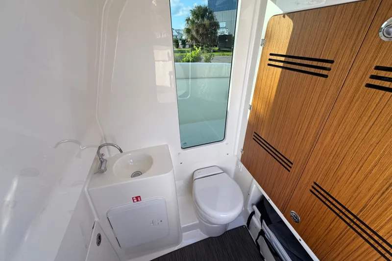 Slide: The Image of Modern bathroom in 2027 Solace 28HCS boat with sink, toilet, and wooden cabinetry. - 30