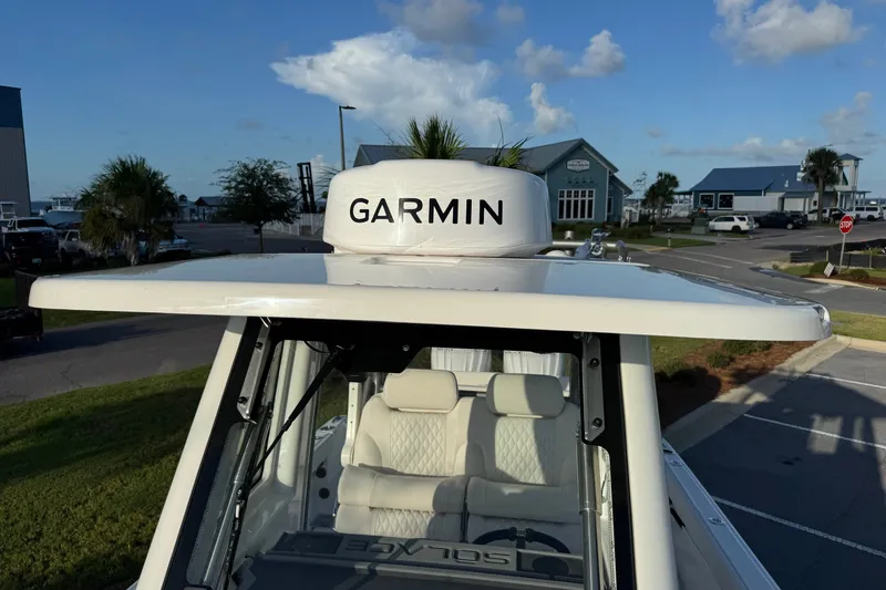 Slide: The Image of 2027 Solace 28HCS boat with Garmin radar, parked in a marina setting. - 28