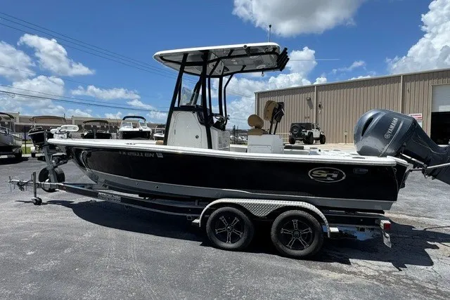 Slide: The Image of 2019 Sea Hunt BX22BR boat on trailer, parked outdoors under a clear sky. - 11