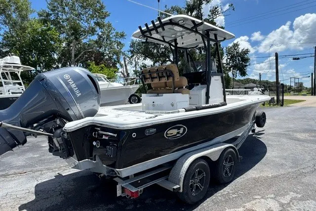 Slide: The Image of 2019 Sea Hunt BX22BR boat with Yamaha engine on a trailer, parked outdoors. - 2