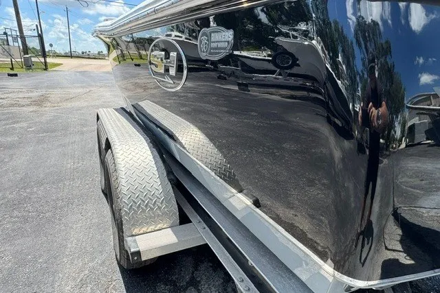 Slide: The Image of 2019 Sea Hunt BX22BR boat on trailer, reflecting surroundings under clear sky. - 10