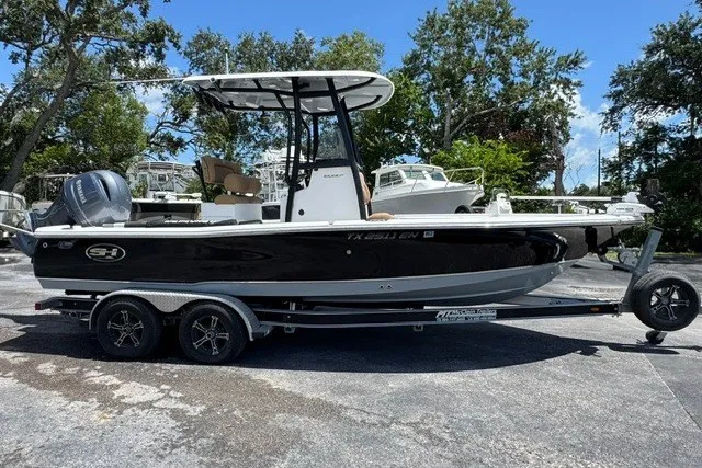 Slide: The Image of 2019 Sea Hunt BX22BR boat on trailer, black hull, parked outdoors. - 1