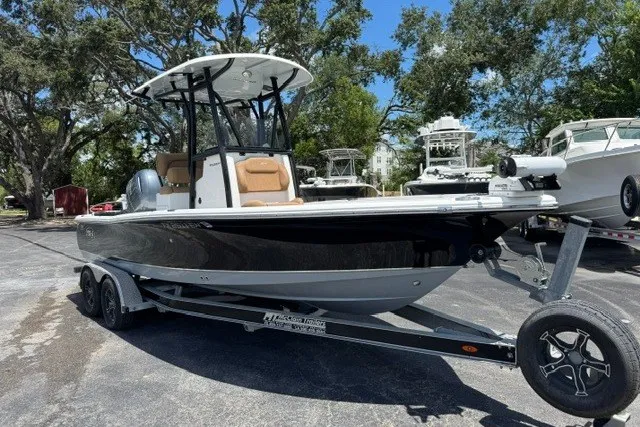 Slide: The Image of 2019 Sea Hunt BX22BR boat on trailer, parked outdoors with trees in the background. - 0
