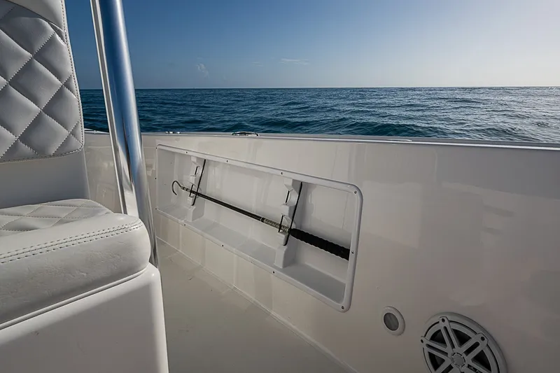 Slide: The Image of 2019 Ocean Master 296 boat interior with ocean view, featuring white seating and storage compartment. - 9
