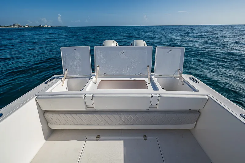 Slide: The Image of 2019 Ocean Master 296 boat with open storage compartments on calm ocean waters. - 16