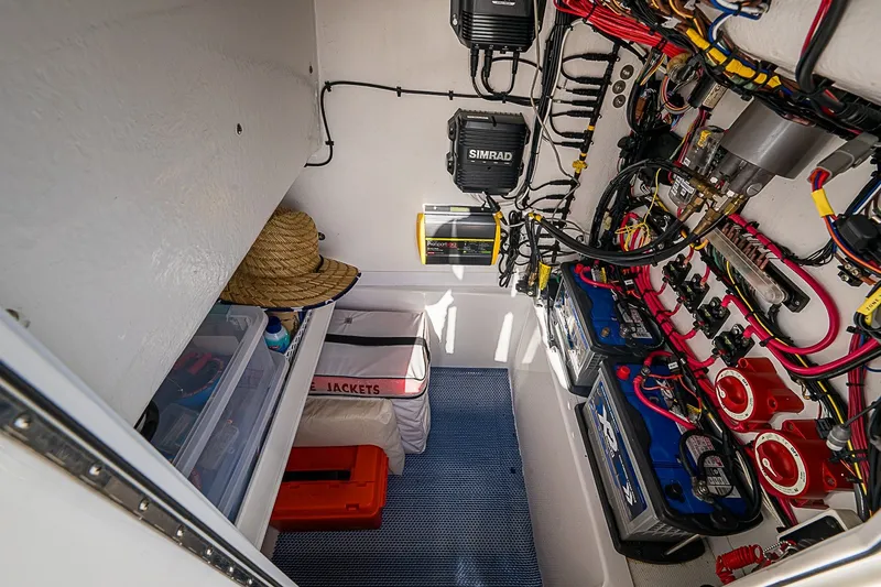 Slide: The Image of Electrical compartment of 2019 Ocean Master 296 boat with wiring, batteries, and storage. - 13