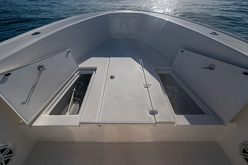 Slide: The Image of 2019 Ocean Master 296 boat deck with open storage compartments, on calm sea. - 6