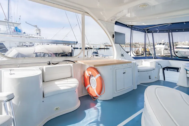 Slide: The Image of Spacious interior of 2003 Bluewater Yachts Custom 6000, featuring seating and marina view. - 7
