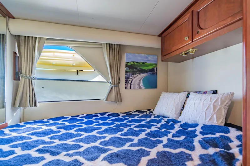 Slide: The Image of Cozy bedroom in 2003 Bluewater Yachts Custom 6000 with nautical decor and window view. - 48