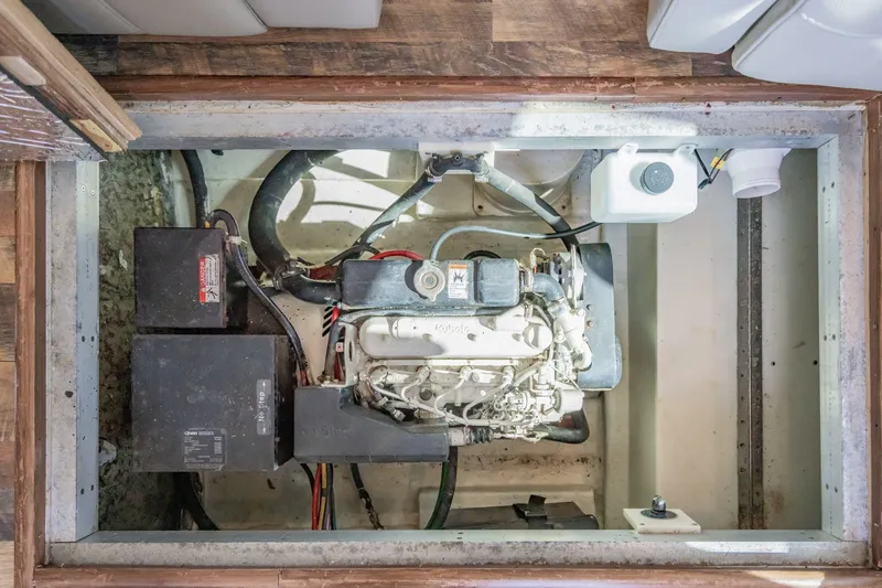 Slide: The Image of Engine compartment of 2003 Bluewater Yachts Custom 6000, showcasing mechanical components and battery. - 86