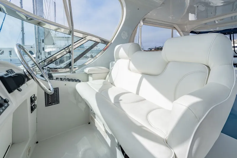 Slide: The Image of Luxurious helm seating on 2003 Bluewater Yachts Custom 6000, featuring sleek white upholstery. - 79