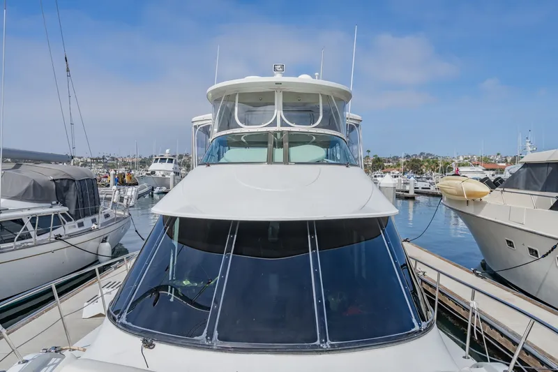 Slide: The Image of 2003 Bluewater Yachts Custom 6000 docked in a marina, surrounded by other boats. - 22