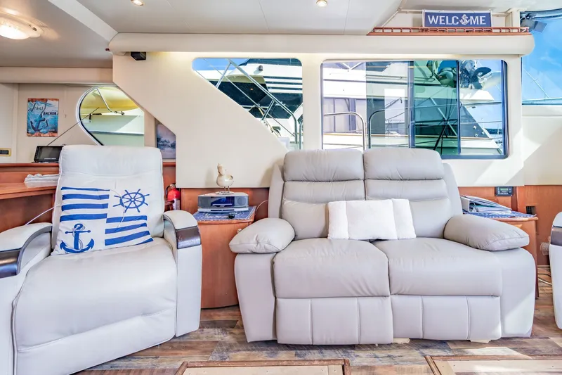 Slide: The Image of Luxurious interior of 2003 Bluewater Yachts Custom 6000 with plush seating and nautical decor. - 27