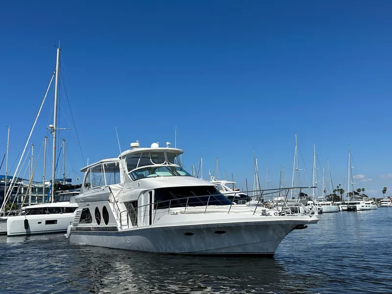 Slide: The Image of A 2003 Bluewater Yachts Custom 6000 docked in a marina, surrounded by other boats. - 2