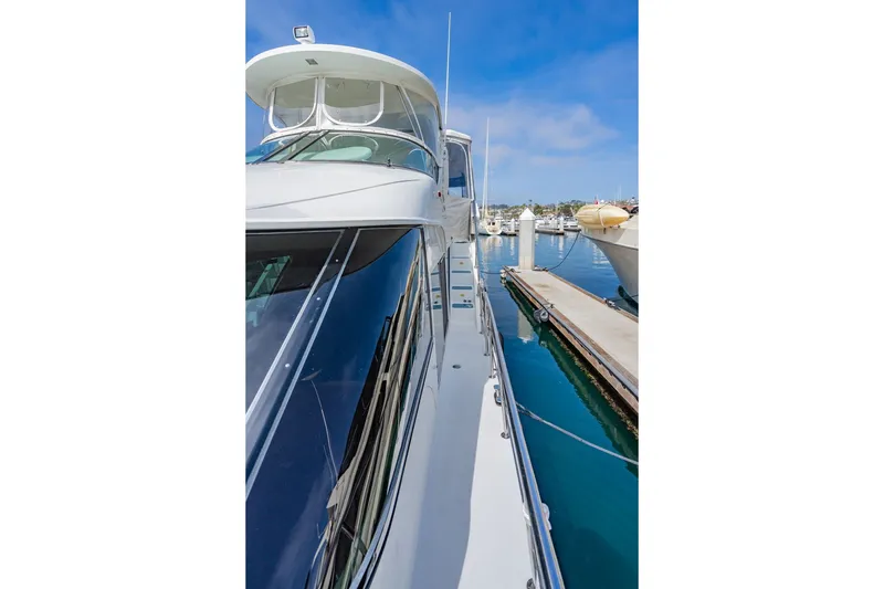 Slide: The Image of 2003 Bluewater Yachts Custom 6000 docked at marina, showcasing sleek design and modern features. - 19