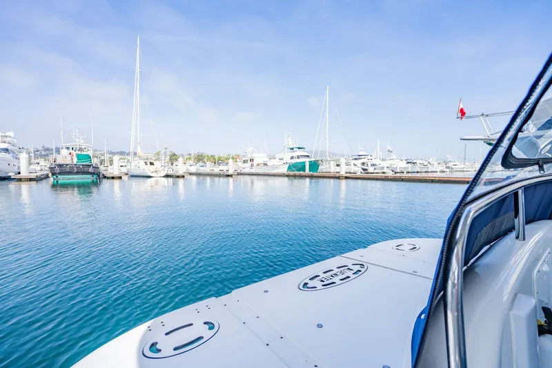 Slide: The Image of 2003 Bluewater Yachts Custom 6000 in marina, surrounded by other boats under clear sky. - 17