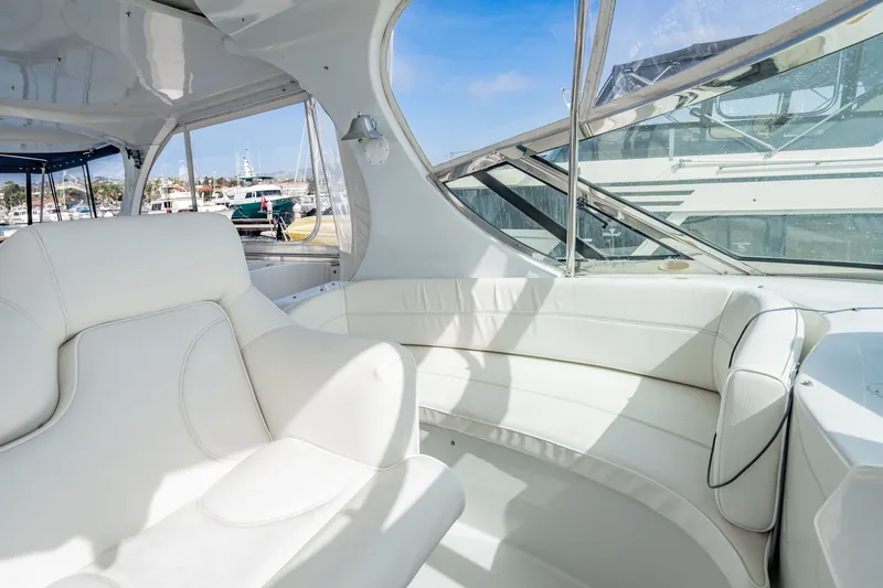 Slide: The Image of Luxurious interior of 2003 Bluewater Yachts Custom 6000 with white seating and marina view. - 80