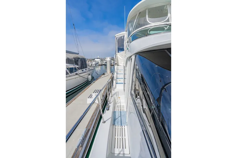 Slide: The Image of 2003 Bluewater Yachts Custom 6000 docked, showcasing sleek design and spacious deck. - 18