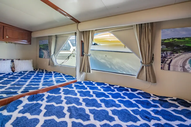Slide: The Image of Luxurious cabin interior of 2003 Bluewater Yachts Custom 6000 with patterned bedding and scenic artwork. - 49