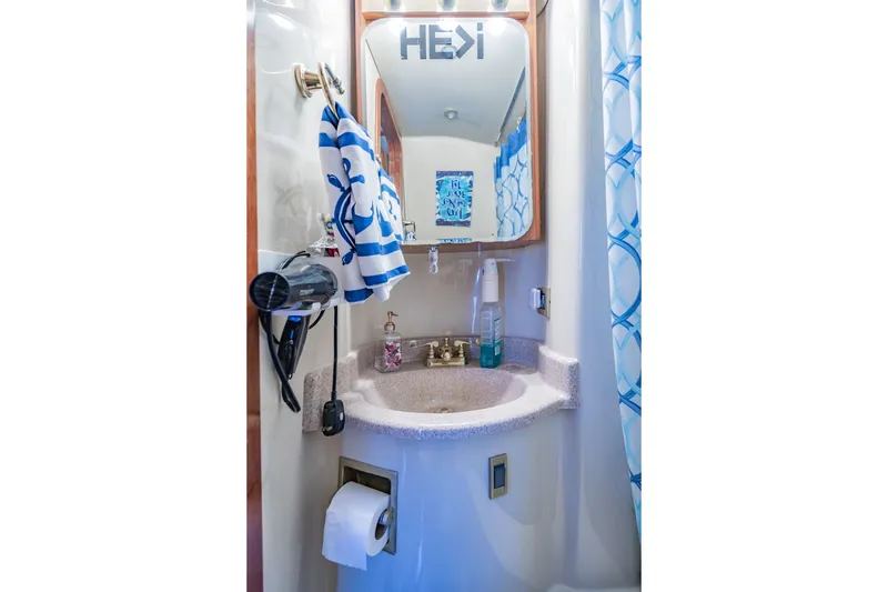 Slide: The Image of Compact bathroom in 2003 Bluewater Yachts Custom 6000, featuring sink, mirror, and nautical decor. - 67