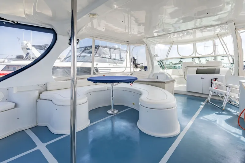 Slide: The Image of Spacious interior of 2003 Bluewater Yachts Custom 6000 with white seating and blue flooring. - 10