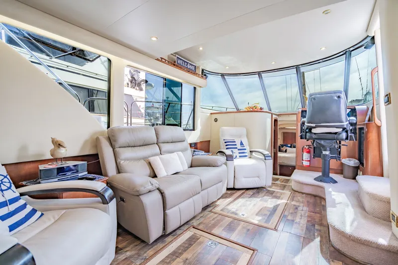 Slide: The Image of Luxurious interior of 2003 Bluewater Yachts Custom 6000 with plush seating and panoramic windows. - 28