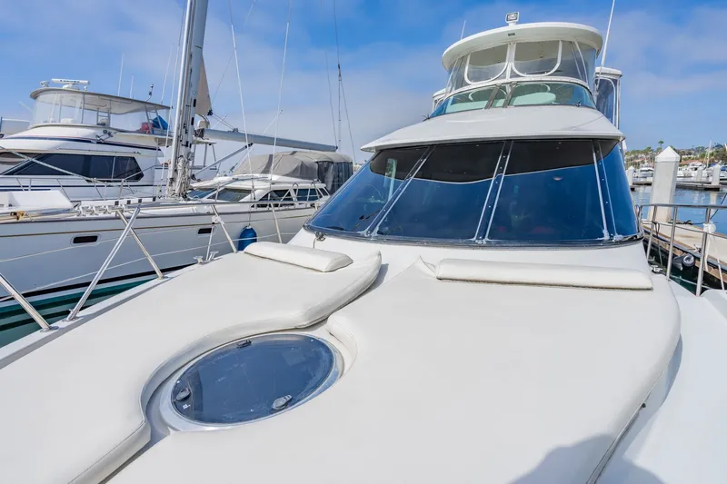 Slide: The Image of 2003 Bluewater Yachts Custom 6000 docked at marina, showcasing sleek design and spacious deck. - 23