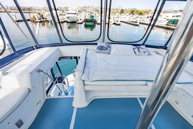 Slide: The Image of Luxurious 2003 Bluewater Yachts Custom 6000 interior with cozy bed and marina view. - 16