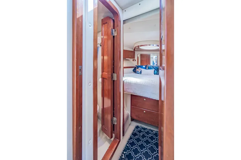Slide: The Image of Luxurious cabin interior of 2003 Bluewater Yachts Custom 6000 with wooden accents and cozy bedding. - 58