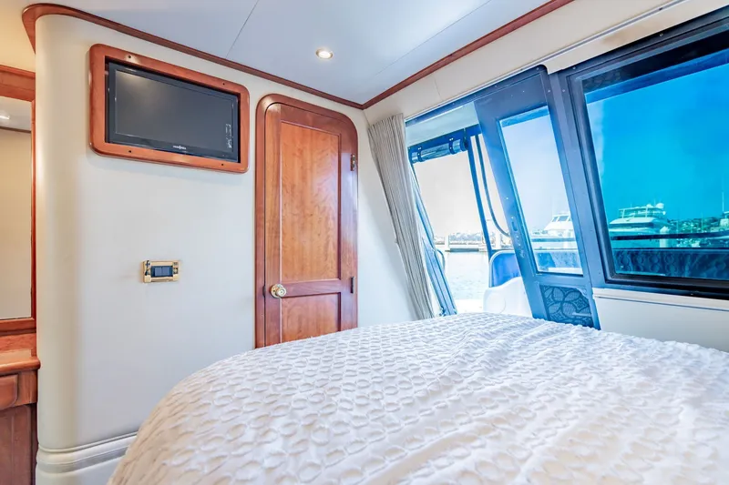 Slide: The Image of Luxurious 2003 Bluewater Yachts Custom 6000 bedroom with waterfront view and elegant interior. - 65